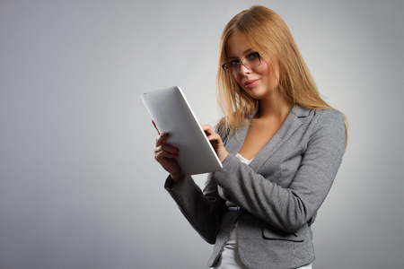 眼镜与平板电脑 Pc 在灰色的背景上的年轻女子