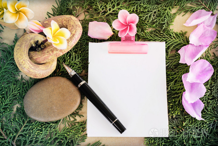 注意到张空白的纸和笔用鲜花和绿叶