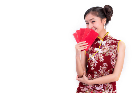 在中国春节联欢晚会上, 年轻的亚洲美女穿着旗袍, 拿着一包钱的手势。假日和生活方式概念。旗袍穿衣