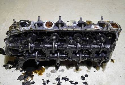 汽缸块的头。汽缸的头从发动机上卸下来修理。发动机油中的零件。汽车发动机维修服务