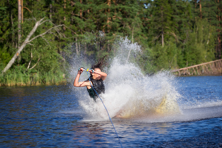 黑发女人骑在一个夏天湖滑水