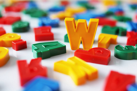 字母 W 在五颜六色的字母在磁铁之间的字母