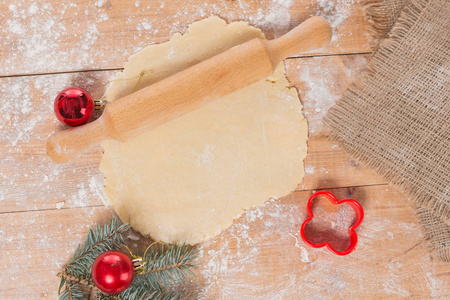在一个木制板面团为圣诞节曲奇饼, 辗压别针, 一棵圣诞树的分支, 曲奇饼形状在桌