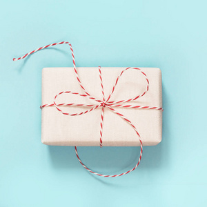 圣诞礼物包裹在白色的纸与红色的绳子丝带蓝色。顶部视图和复制空间