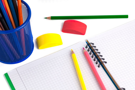 彩色铅笔在篮子, 橡皮擦和笔记本上白背图片