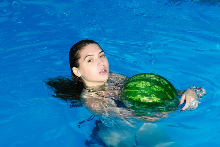 西瓜在游泳池里的女人