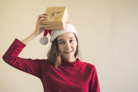 快乐亚洲妇女身着红色圣诞帽藏品礼品盒
