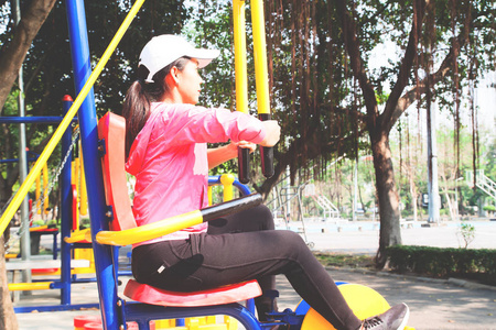 运动的亚洲妇女锻炼与训练设备在公园, 秀丽和健康概念