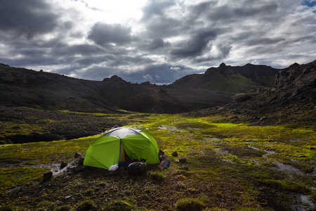 冰岛山脉明亮的石灰绿色帐篷里的野外露营