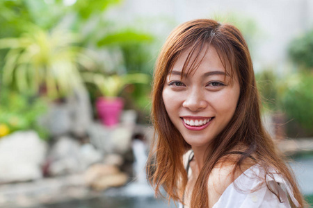 美丽的女人游泳池在度假村放松的肖像年轻的亚洲女孩幸福的微笑