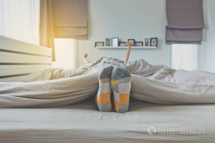 脚在床上聚焦脚与袜子, 脚和舒展在醒以后懒洋洋地