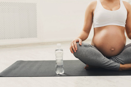 被认出的怀孕的妇女与瓶水