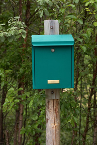 在木桩上的绿色邮箱