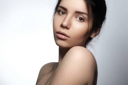 美丽的年轻女子,与完美干净光泽的皮肤,自然时尚化妆.