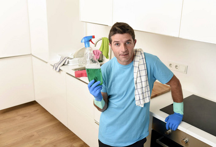 年轻快乐的人，拿着洗洗涤剂喷雾瓶中微笑的橡胶手套