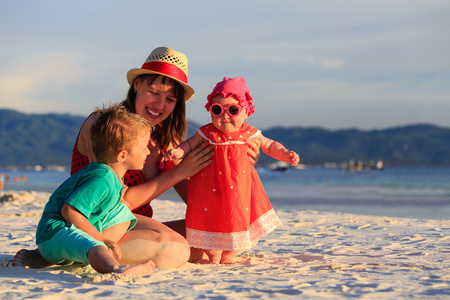 母亲和孩子们在沙滩上玩耍