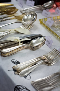 老勺子和餐具在古董市场上。出售的古董博览会