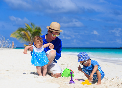 父亲和孩子们去做热带海滩沙子城堡