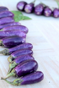 紫色茄子上烹煮新鲜木材背景