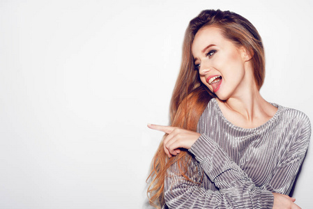 女人惊喜显示产品.美丽的女孩, 长发指向侧面.表达面部表情.