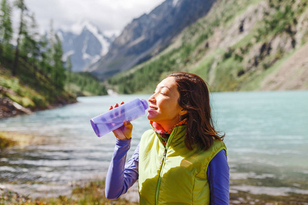 徒步旅行的女人从山涧里喝新鲜的水