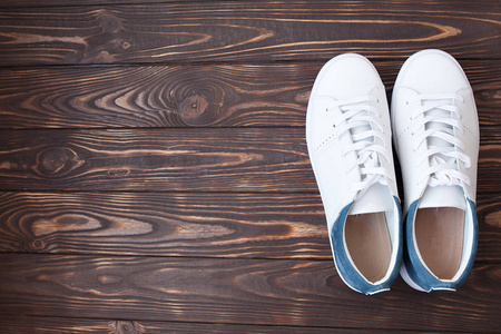 棕色背景白色运动鞋照片