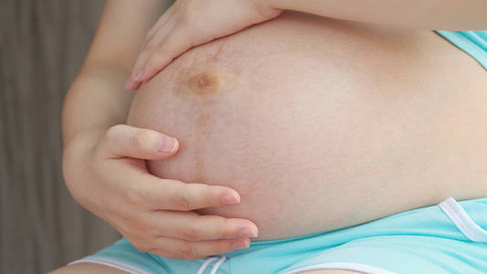 孕妇爱抚她的腹部