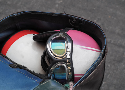 旧式摩托车头盔在摩托车的最后储存袋中。关闭图像