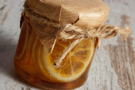 在木制的桌子，健康营养上的玻璃罐蜂蜜柠檬