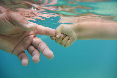 婴儿和父亲双手在水中