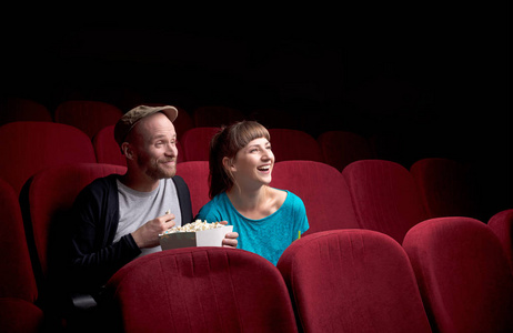 年轻夫妇坐在红色电影院