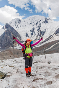 一个妇女冒险家和登山者在一个山通行证附近在冰川在盔甲和与背包