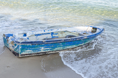 旧的蓝色遗弃渔船西西里岛沙海滩上