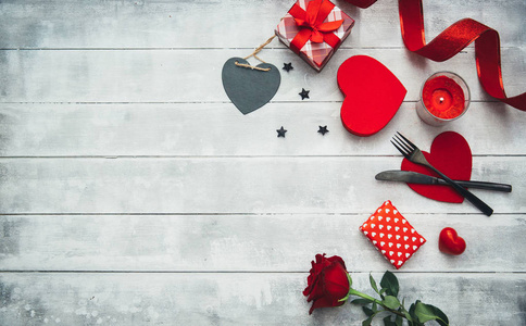 情人节餐桌设置用叉子, 刀, 红心, 丝带和玫瑰。情人节背景或第一次约会