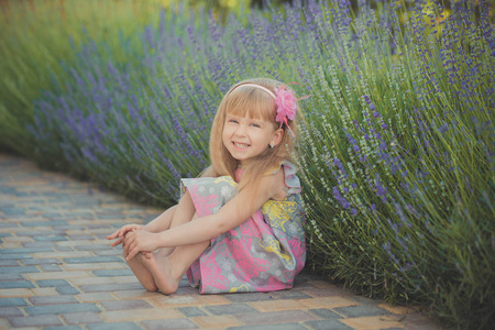 金发碧眼的小女孩有一定的乐趣在夏季假期的时尚风格会议接近绿色春天草
