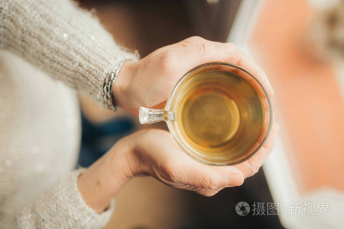 女性手里拿着一杯热茶