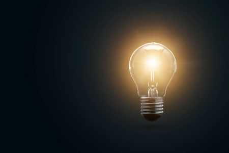 成功光电灯泡在黑暗的背景下发光.这个概念是一个成功的想法照片