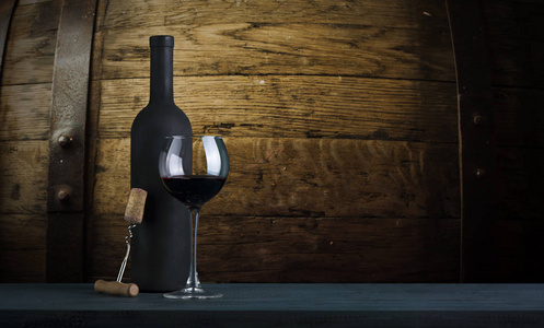 红葡萄酒瓶和木制桶上的红酒杯