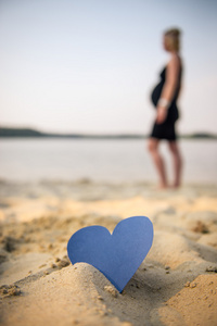 心和怀孕的女孩，在沙滩上