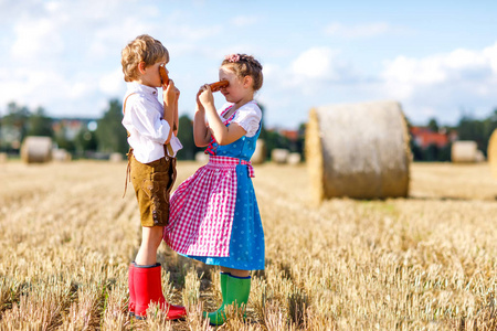 两个孩子，男孩和女孩在传统巴伐利亚的传统服饰，在麦田