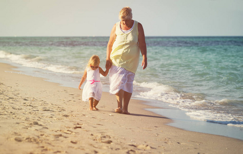 小女孩快乐祖母走在海滩
