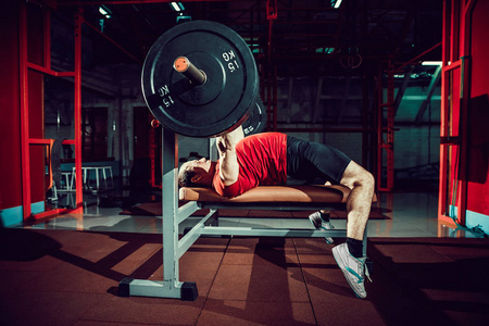 男人做卧推在健身房锻炼照片