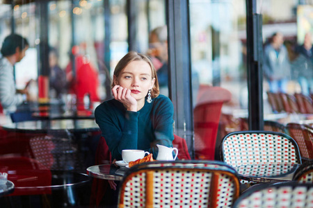 法国巴黎咖啡馆里喝咖啡的年轻优雅的女人照片