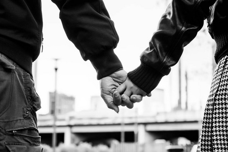 在城市的情侣手拉手的特写, 黑白照片