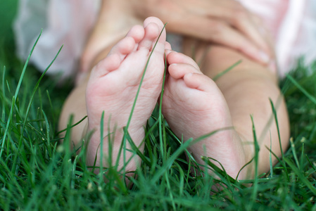 在户外的新鲜绿色草地上小小的婴儿脚