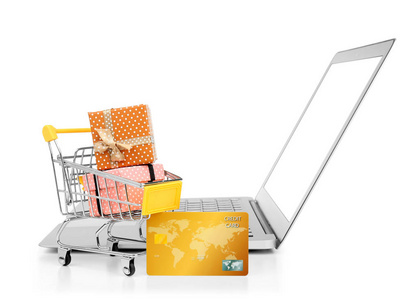笔记本电脑, 信用卡和小购物车与礼品盒在白色背景.网络购物理念照片