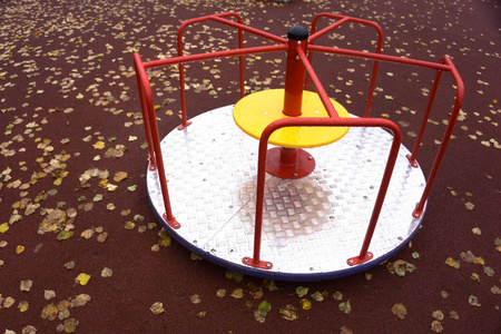 小木马。五颜六色的儿童游乐场在公园里。童年设备和红色背景