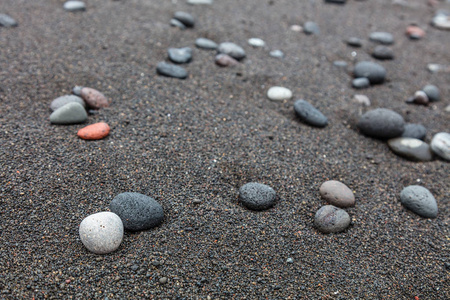 在新加拉惹，印度尼西亚巴厘岛的黑沙海滩上的鹅卵石