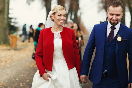 新郎和新娘在红色夹克在公园散步