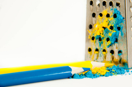 两支铅笔，黄色和蓝色说谎附近刨丝器
